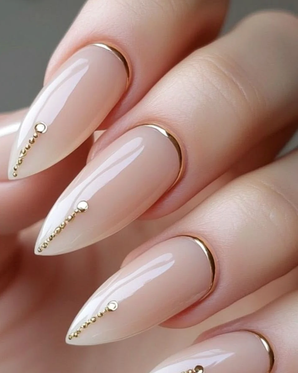 Almond-shaped nude nails with gold details